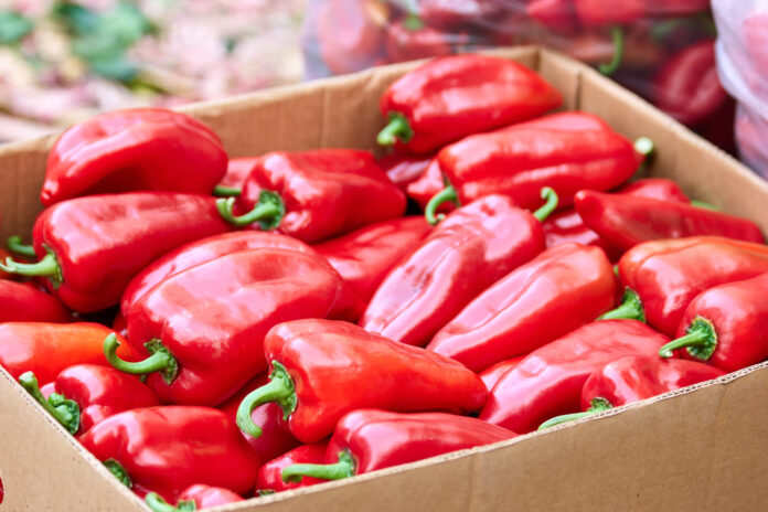 Cardboard box with red bell peppers.